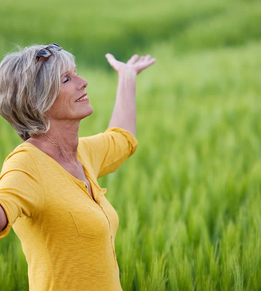 Leber und Ayurveda eine ältere Frau fühlt sich gesund in der Natur