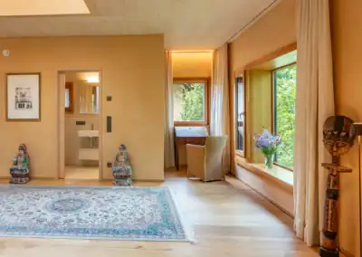 Helles Apartment im RoSana Waldhaus mit orientalischem Teppich, Buddha-Figuren und afrikanischer Skulptur