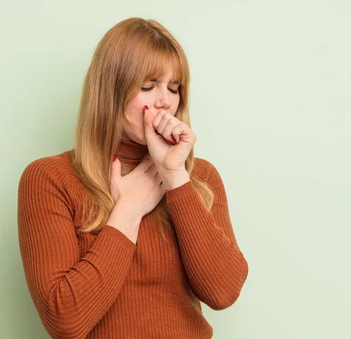 Ayurveda bei Bronchitis Herbst Frau hustet und hält Hand an Hals – Bronchitis-Symptome im Herbst, Ayurveda-Behandlung bei RoSana