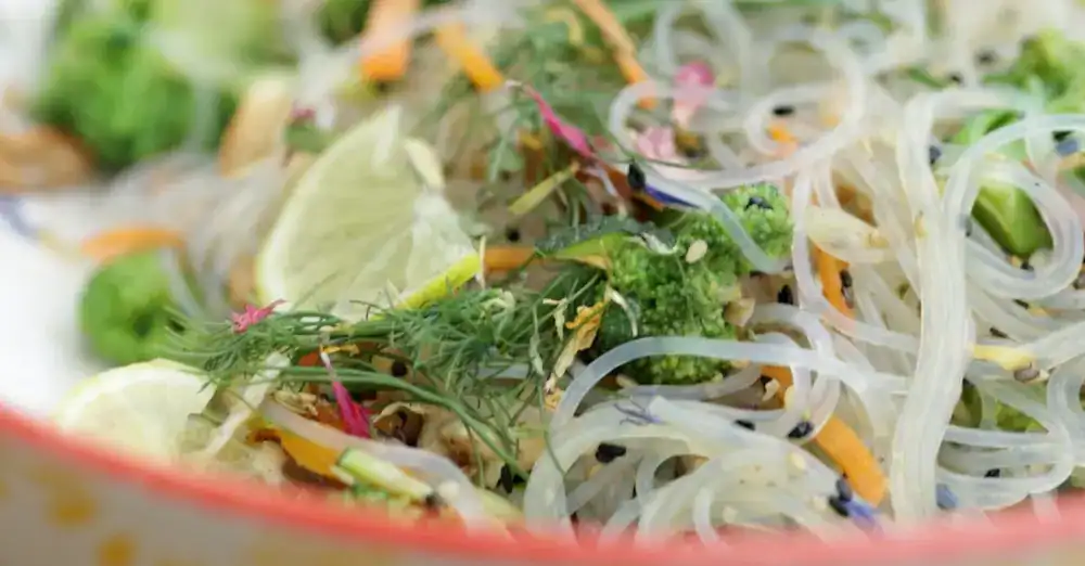 Ayurvedischer Glasnudelsalat mit Brokkoli, Karotten, Dill, Limette und schwarzem Sesam in einer Schüssel